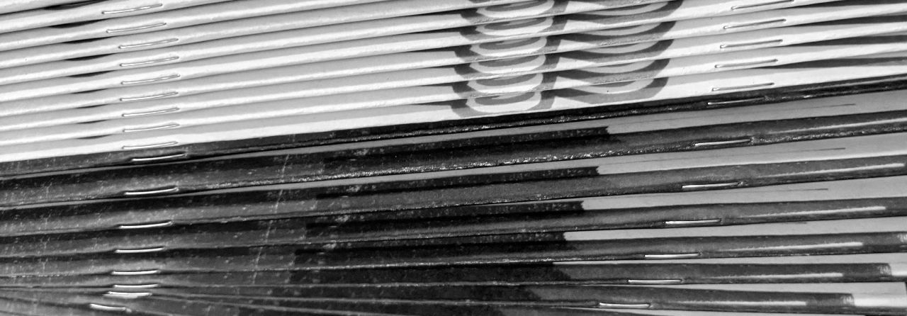 close up of the spines of a stack of stapled zines