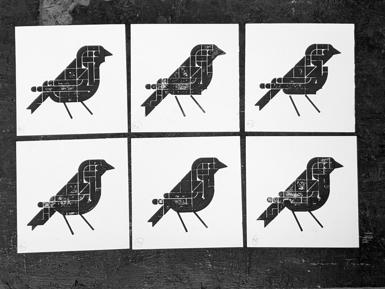 Six square test prints in black ink that hone in on the basic shape and posture of the next bird to print.